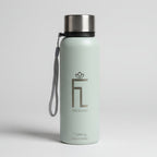 Green water bottle with a logo on a green surface